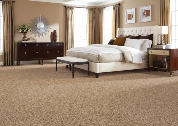 Soft neutral toned bedroom carpet covering the floor beside a bed and nightstand